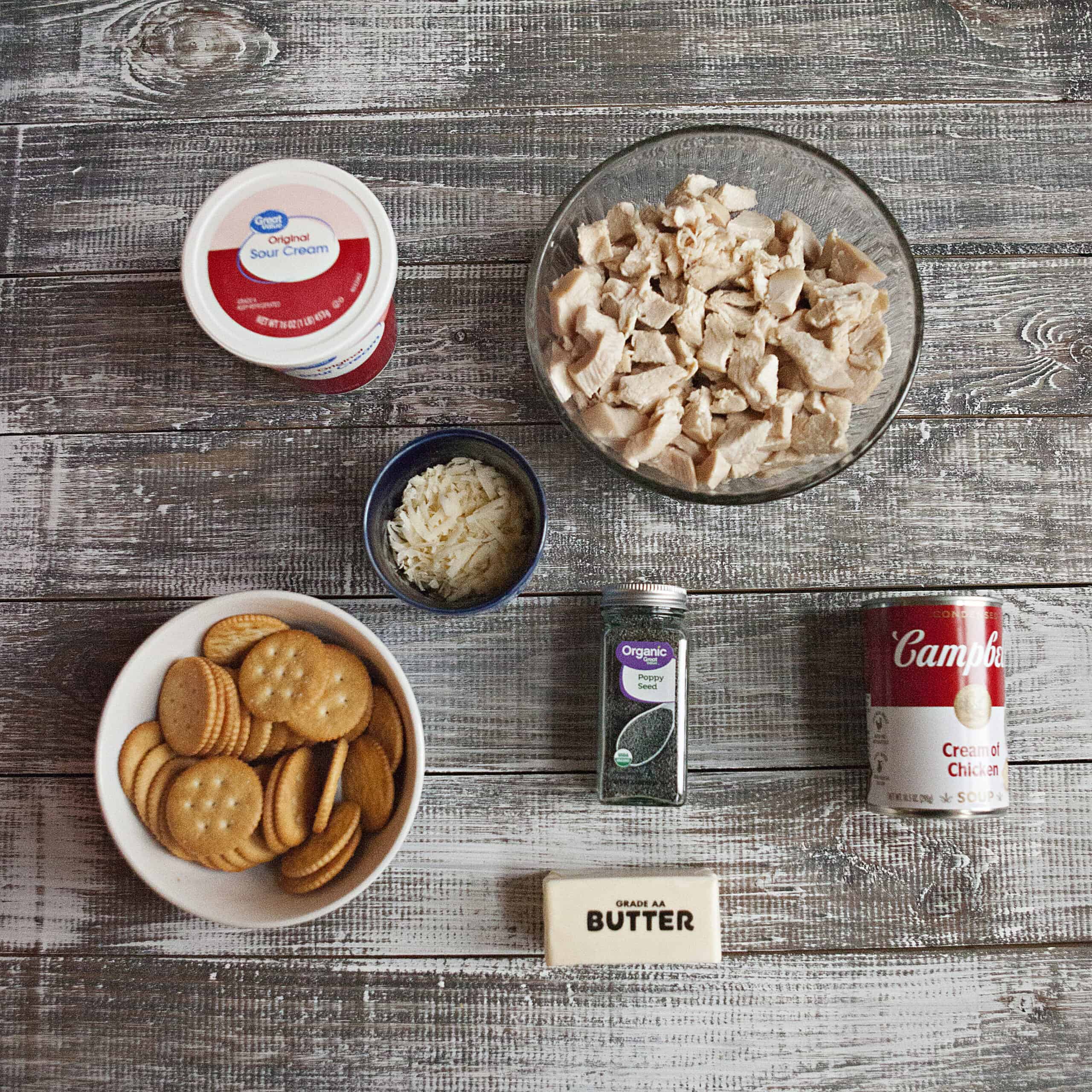 Ingredients for easy poppy seed chicken casserole:  Diced chicken, cream of chicken soup, sour cream, poppy seeds, Ritz crackers, grated Parmesan cheese, and butter.