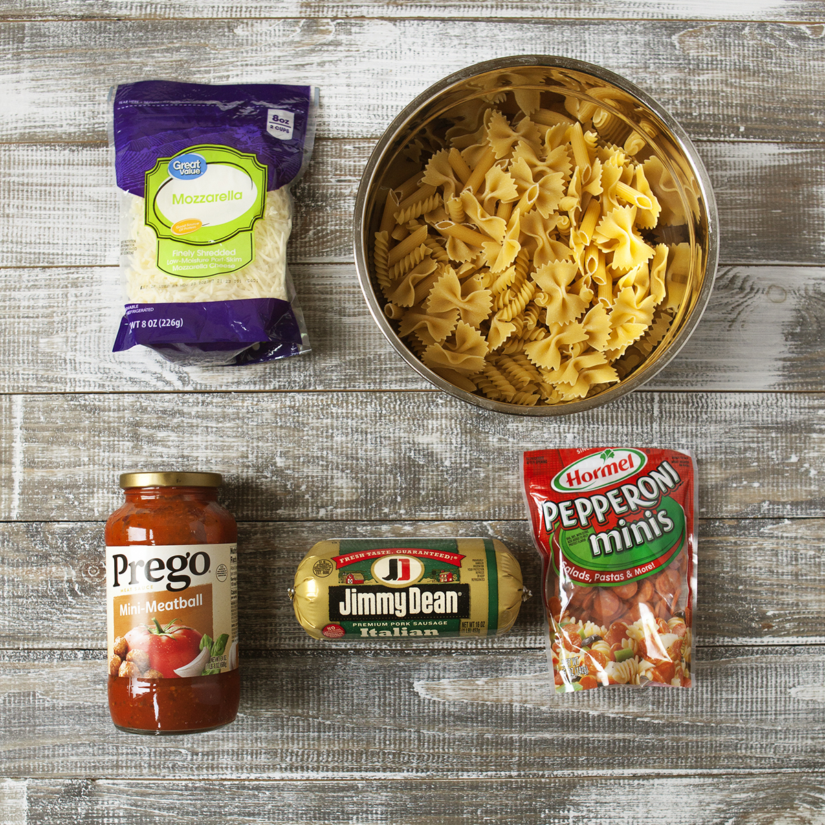 Ingredients for pepperoni pasta bake with Italian sausage and mozzarella: Shredded mozzarella cheese, pasta shapes, marinara sauce, Italian sausage, and mini pepperoni.