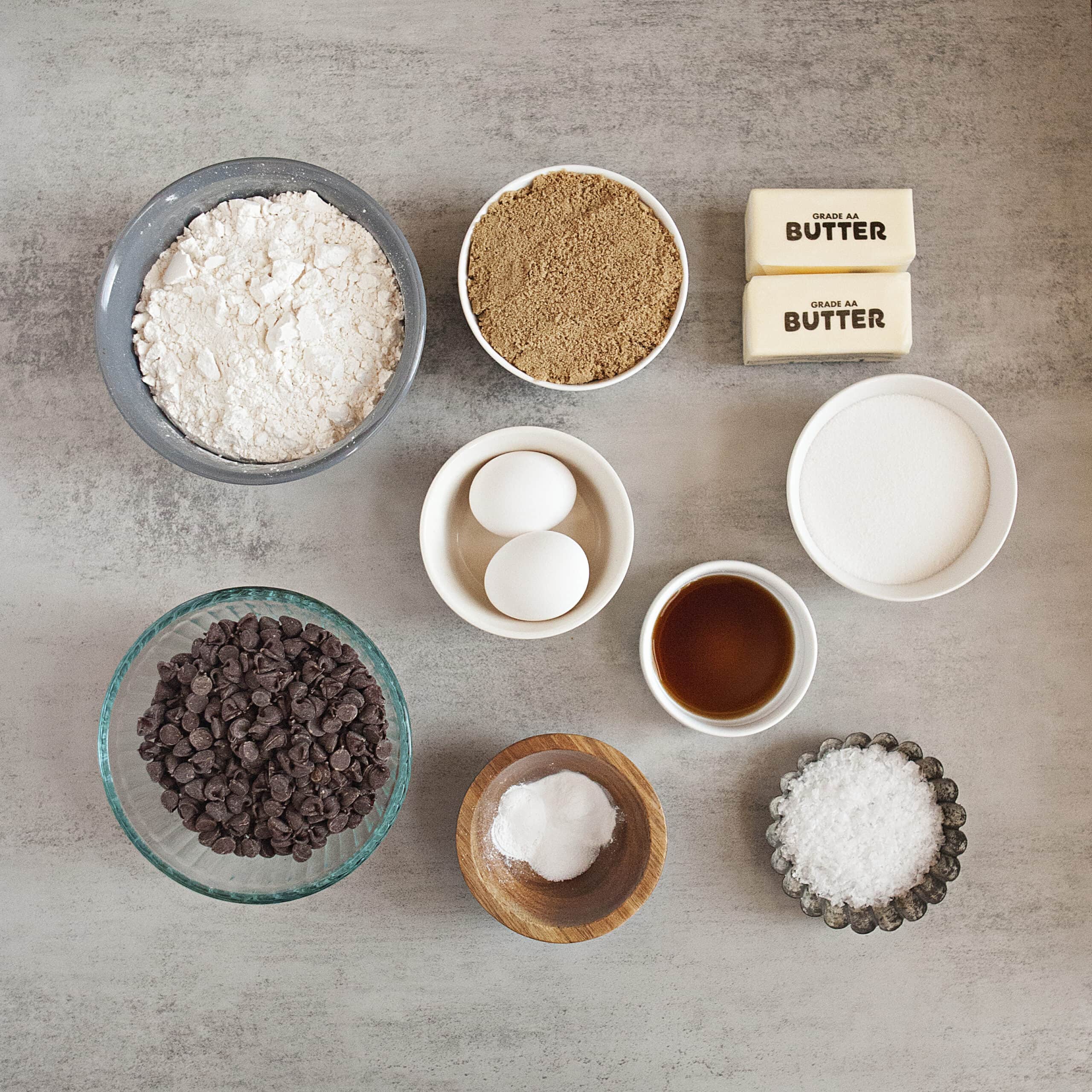 Ingredients for soft chocolate chip cookies:  Flour sugar, brown sugar, eggs, butter, vanilla, chocolate chips, sea salt flakes, salt, baking powder, baking soda.